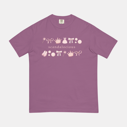 Purple t-shirt with pink and white graphic design that says "scandalocious" on a light gray background