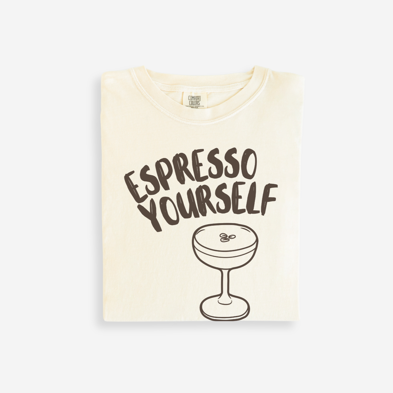 Beige t-shirt with 'Espresso Yourself' text and espresso cup graphic on a white background